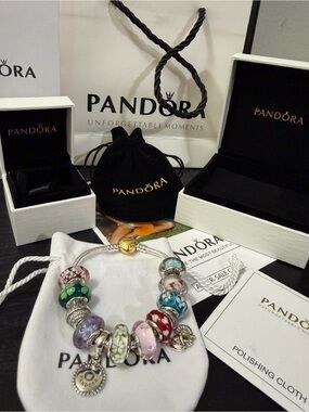 Pandora bracelet in play with 12 charms and all its set of bags and cases.